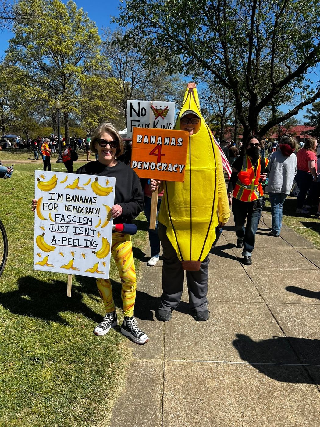 Two marchers with signs, one wearing a banana costume, holding a "Bananas 4 Democracy" placard.
