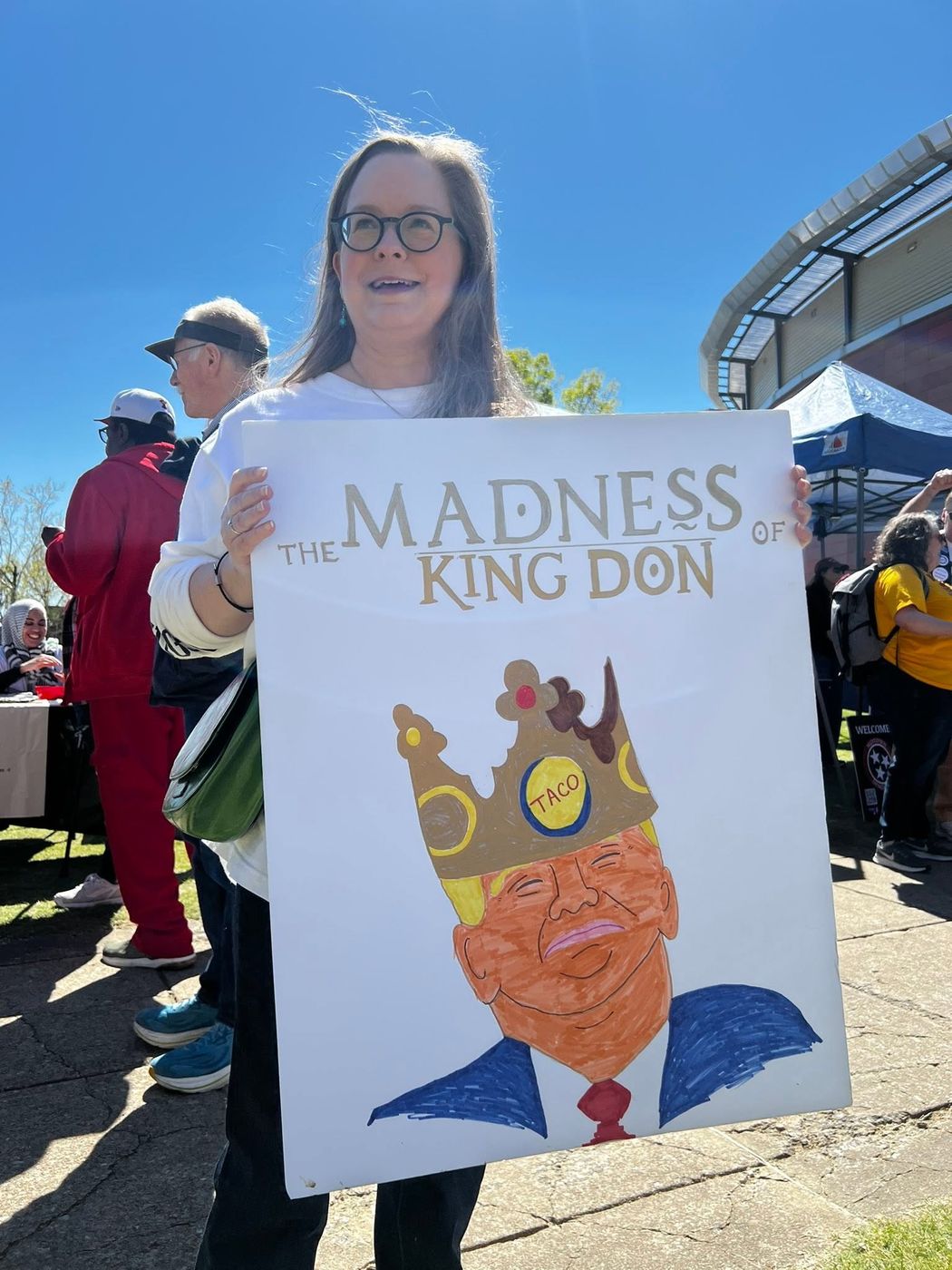 A member holding a large hand-painted protest poster at a Memphis rally.